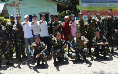 <p>NPA FIREARMS. Officers and men of the 1ST Mechanized Battalion officers pose with NPA surrenderees after the surrender rites. (Photo by Army’s 6th Infantry Division)</p>